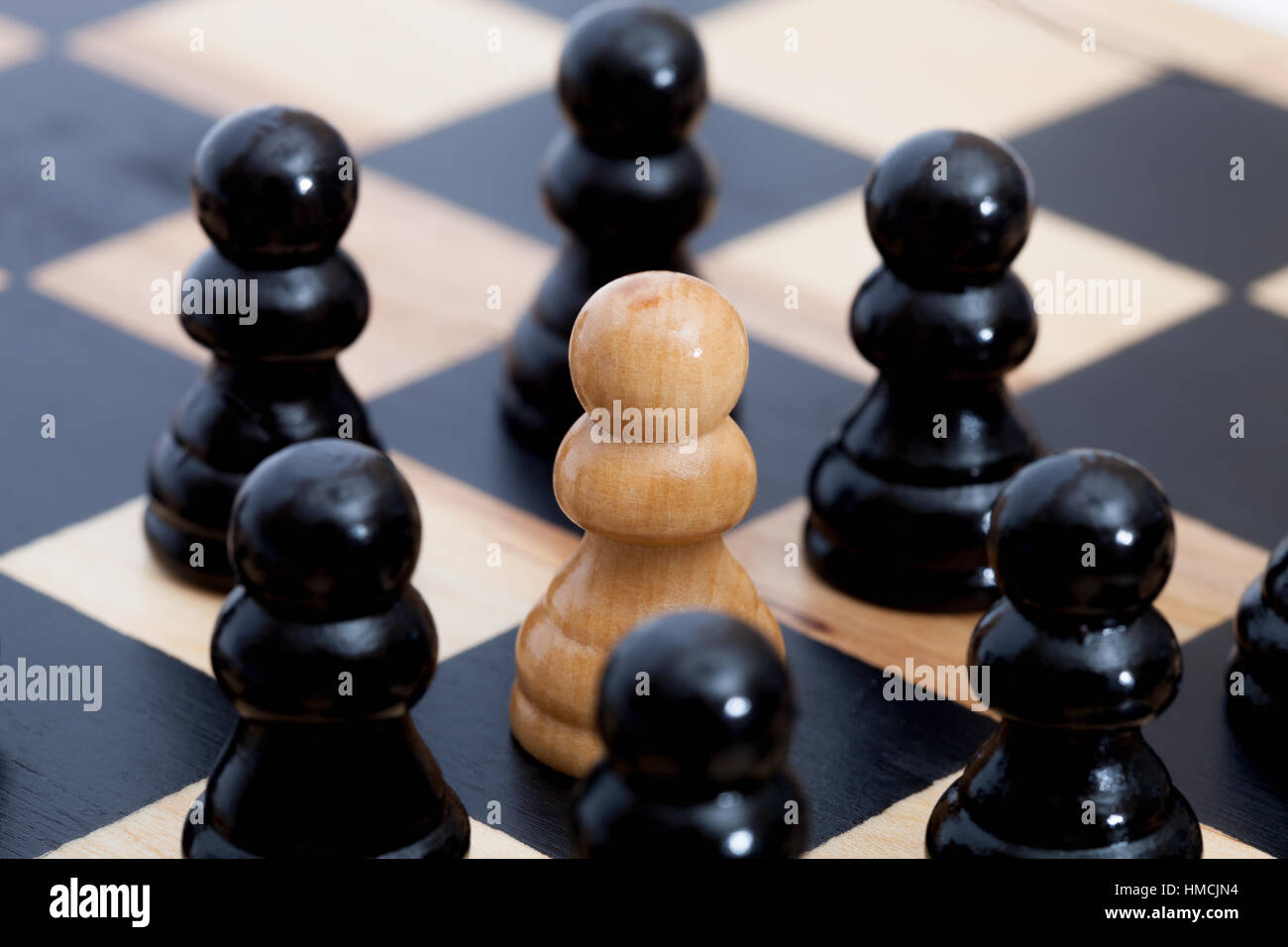 White chess pawn surrounded by black ones Stock Photo