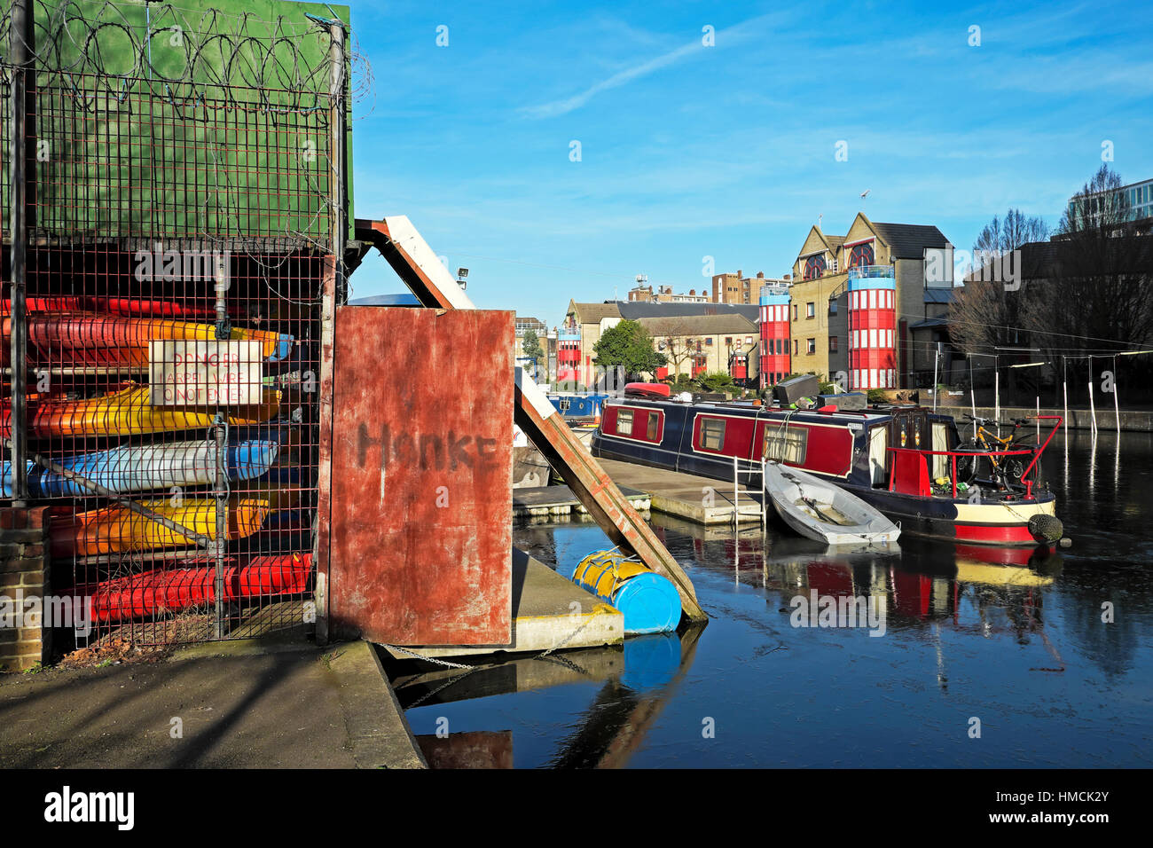 A view of Regents Canal Canoe Club canoes, houseboat, apartments
