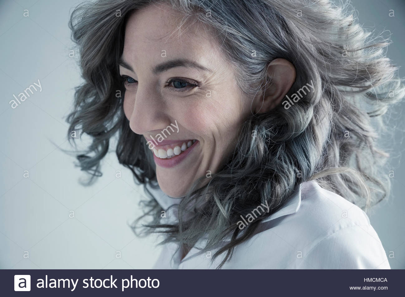 Portrait happy Caucasian mid adult woman with curly gray hair looking away Stock Photo