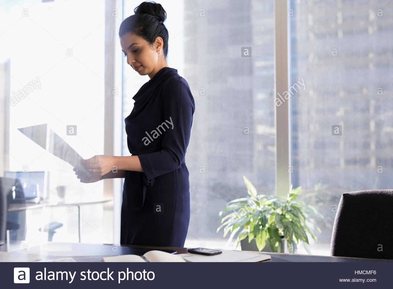 Female lawyer reviewing paperwork in urban office Stock Photo