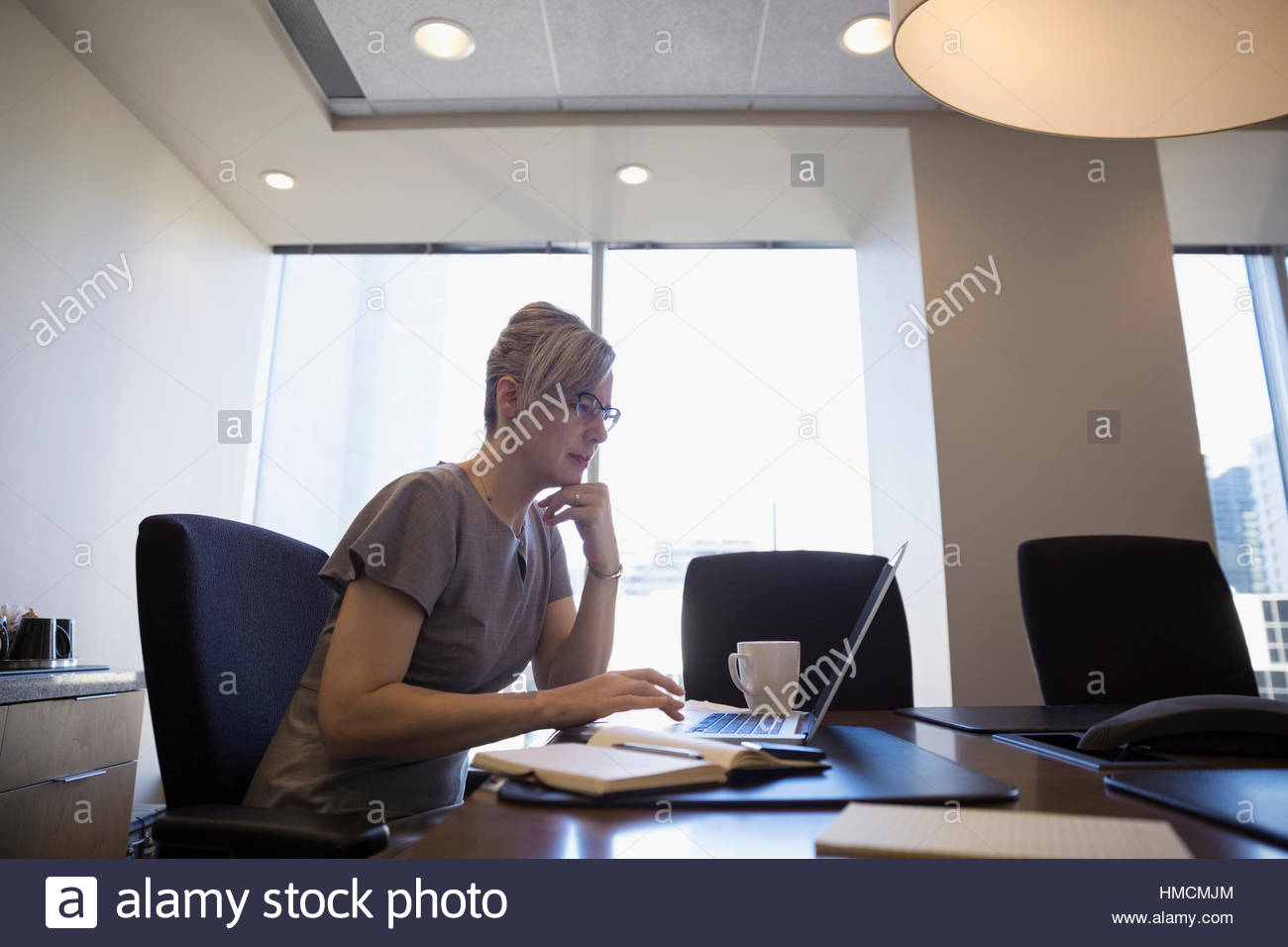 Focused female lawyer working at laptop in conference room Stock Photo