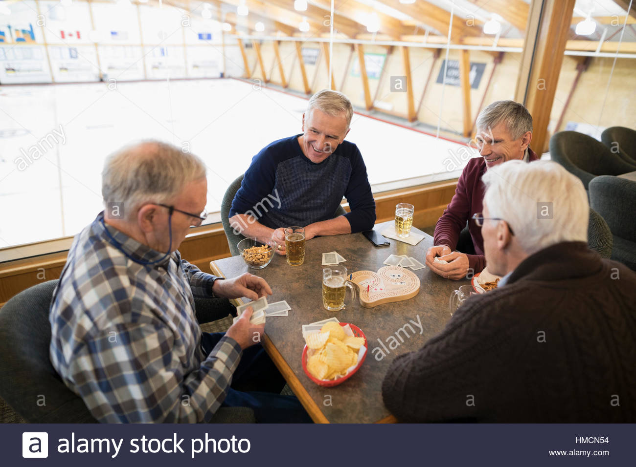 Senior men playing cribbage and drinking beer at curling club Stock Photo Alamy
