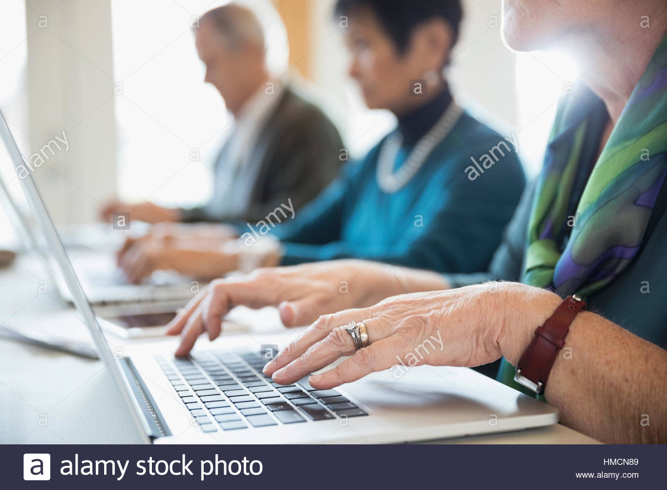 Senior woman student typing at laptop in classroom Stock Photo - Alamy