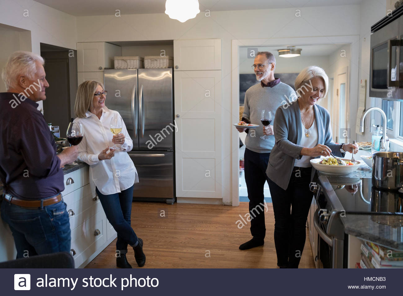 Senior couples cooking and drinking wine in kitchen Stock Photo Alamy