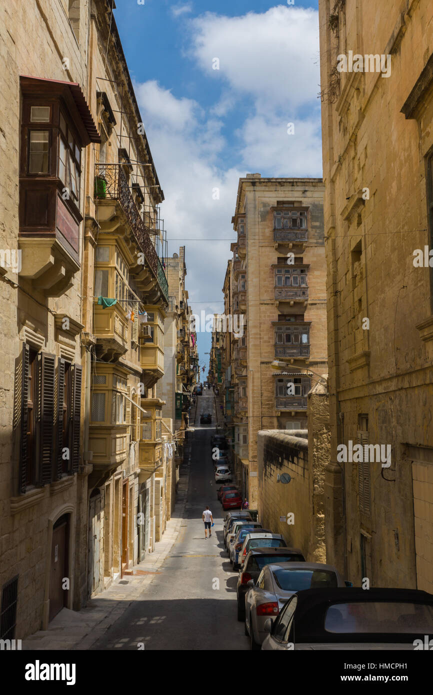 view down the narrow road with parked cars in Valletta, Malta Stock