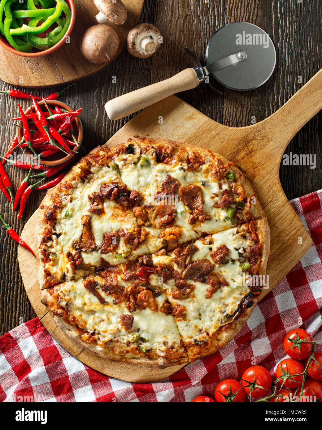 A delicious spicy pork pizza with green pepper, onion, and mushrooms. Stock Photo