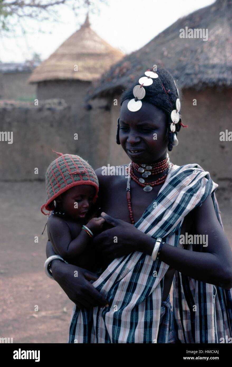 Woman with a traditional hairstyle and her child, monastery in Koubri ...