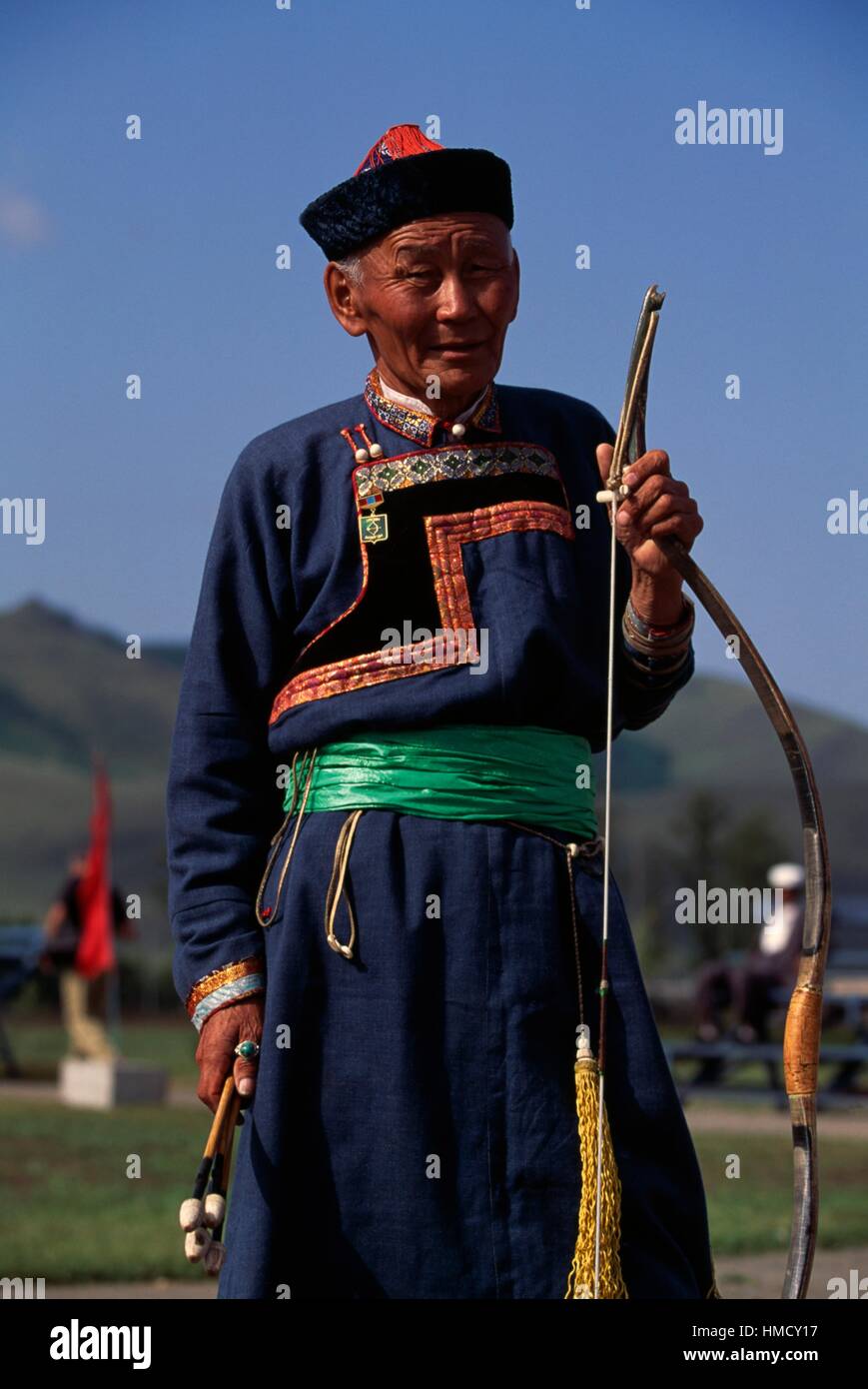 Man wearing traditional clothing holding a bow during the Naadam ...