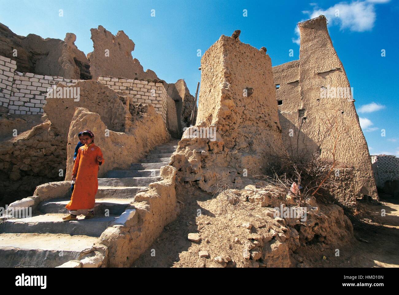 A girl in front of the ruins of a 14th-century mosque, the village of Shali, Siwa Oasis, Egypt. Stock Photo