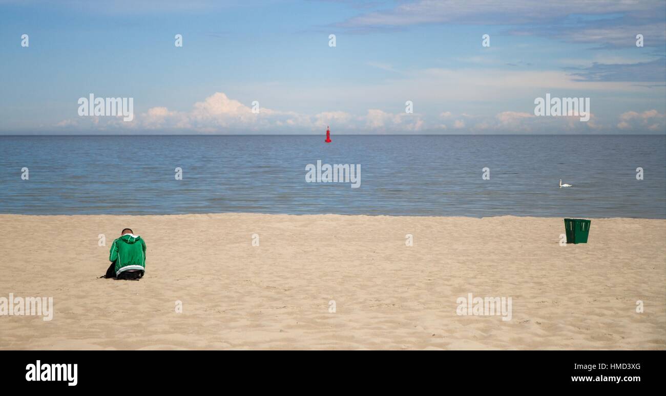 Man sitting on the sandy beach Stock Photo