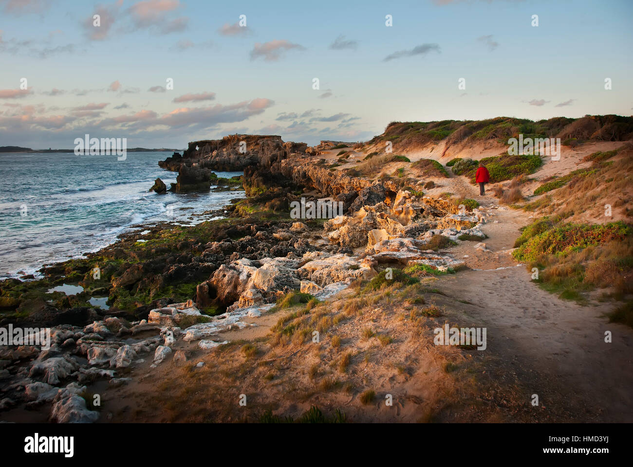 Oint Peron Rockingham person walking in red coat on rocky foreshore path Point Peron ...