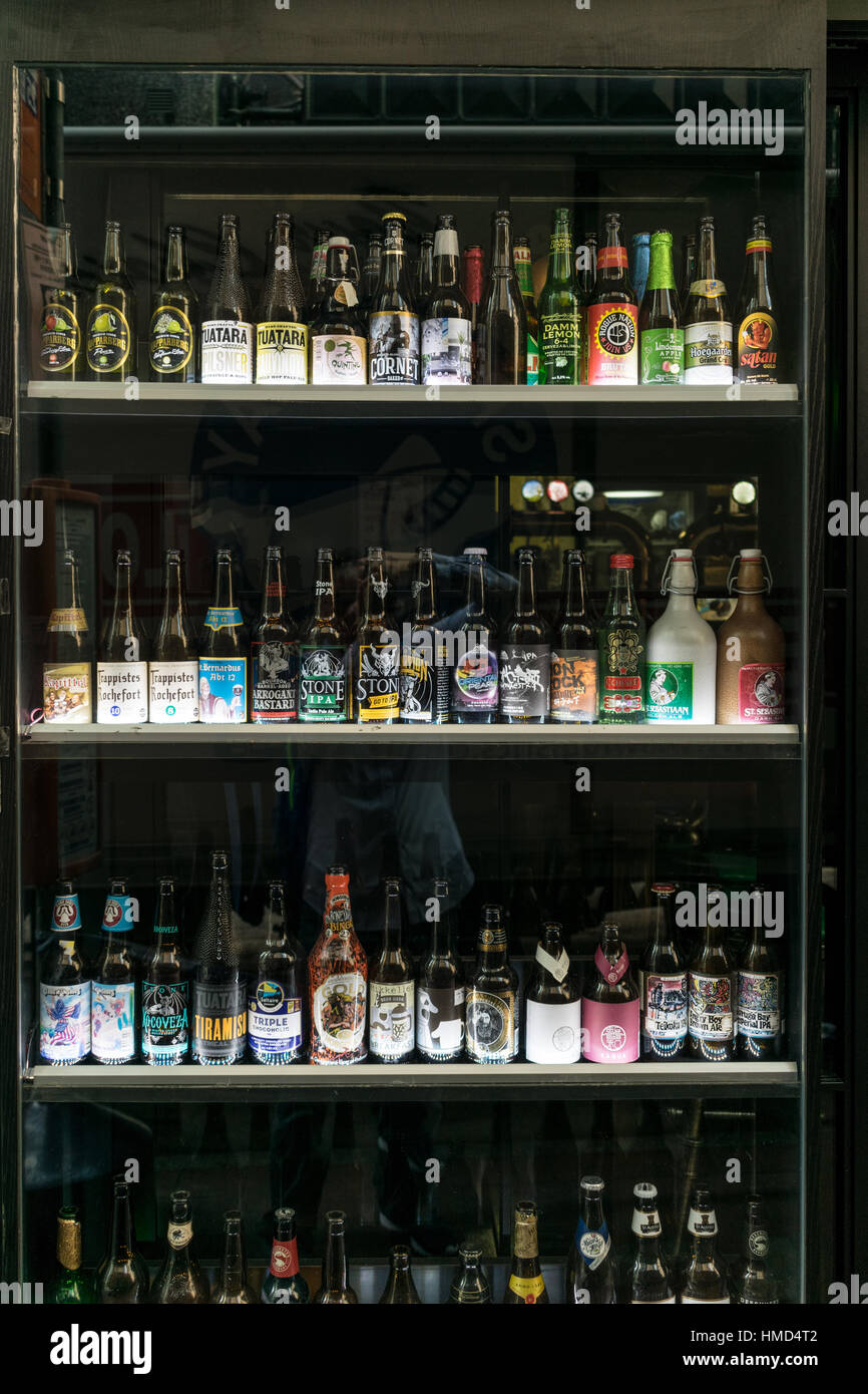Beer bottles arranged on shelves at a bar's glass display in Hong Kong