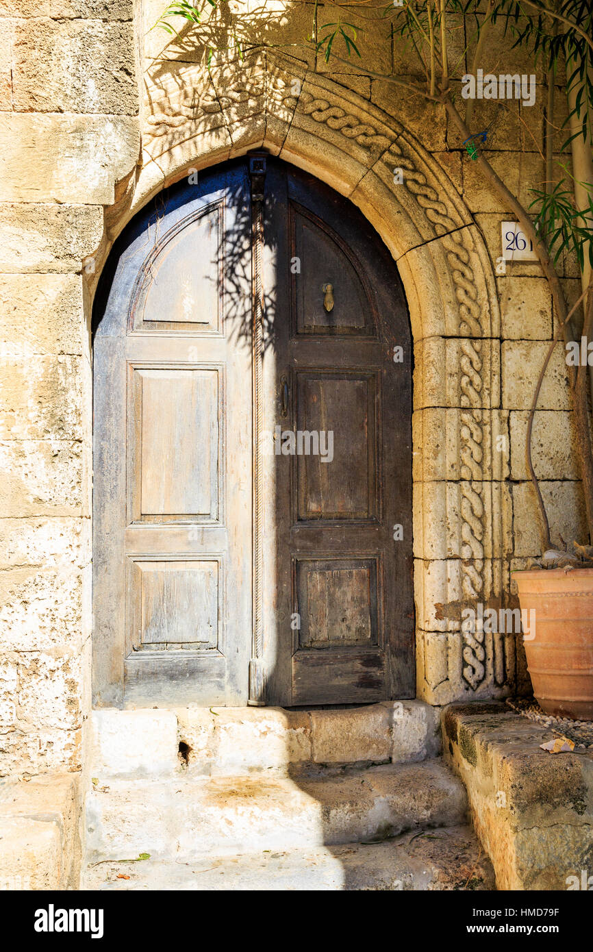 carved stone doorway arch and wooden door, lindos, rhodes, greece Stock Photo