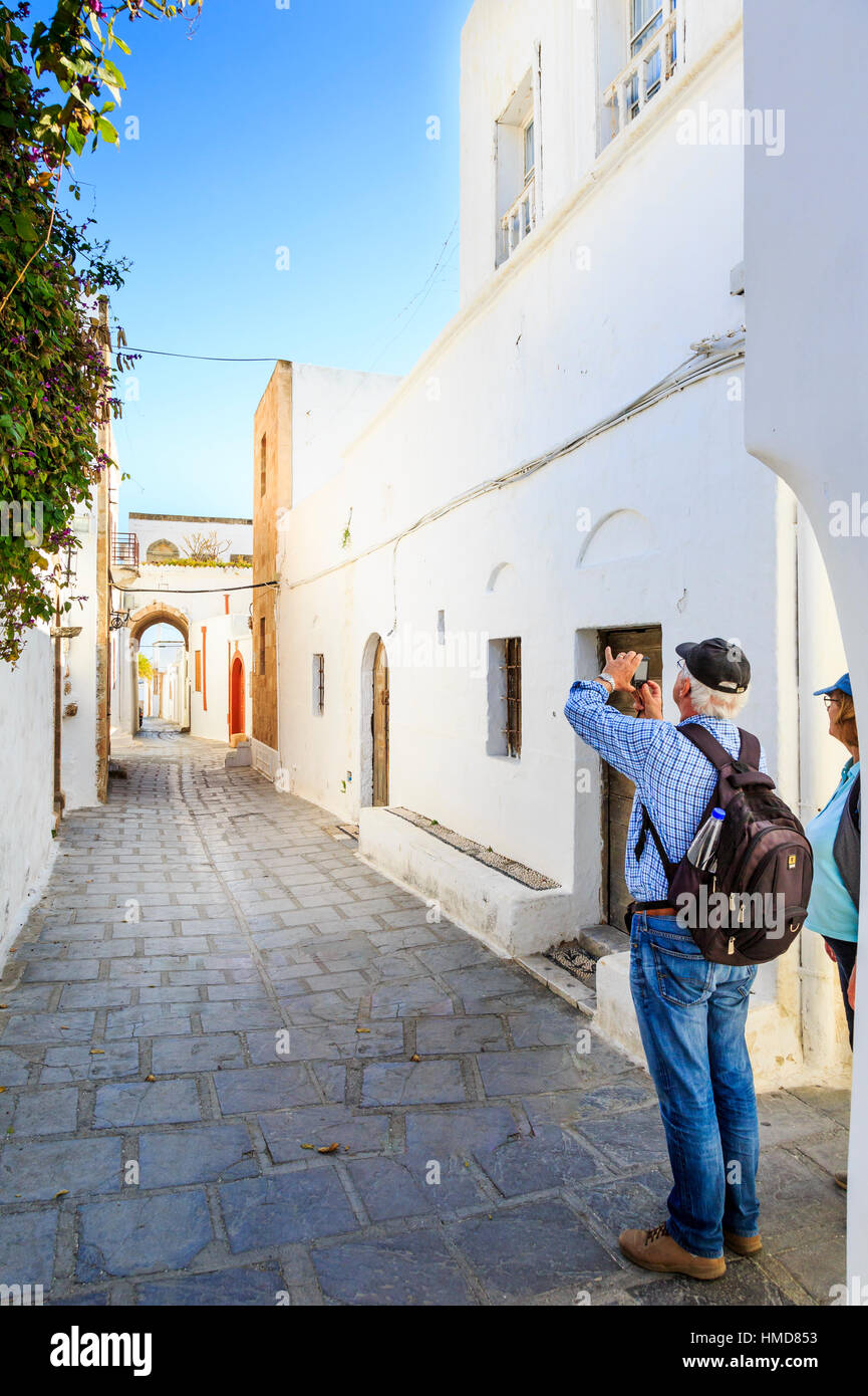 couple walking the white washed streets of lindos, rhodes, greece Stock Photo