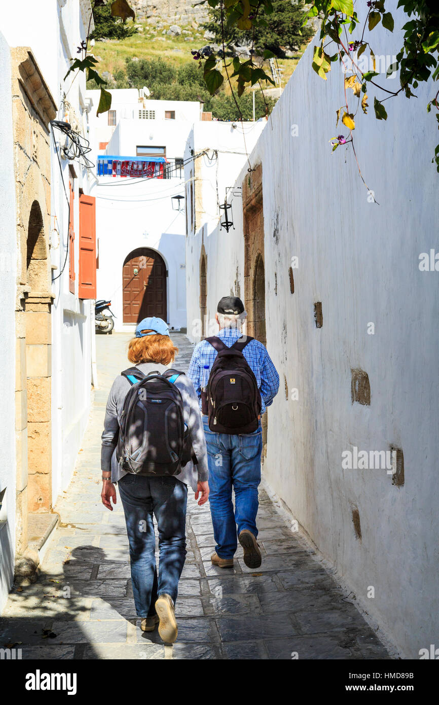 couple walking the white washed streets of lindos, rhodes, greece Stock Photo