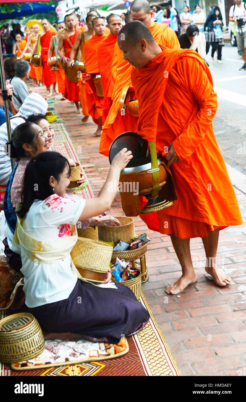 Monks collect food offerings from locals in Luang Prabang,Laos, South East Asia. Stock Photo