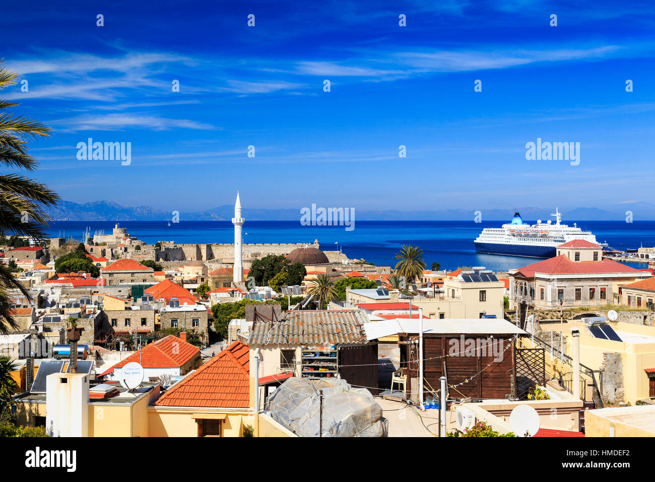 View over Rhodes old town down to mandraki harbour showing rooftops, minarets and the old walls Stock Photo