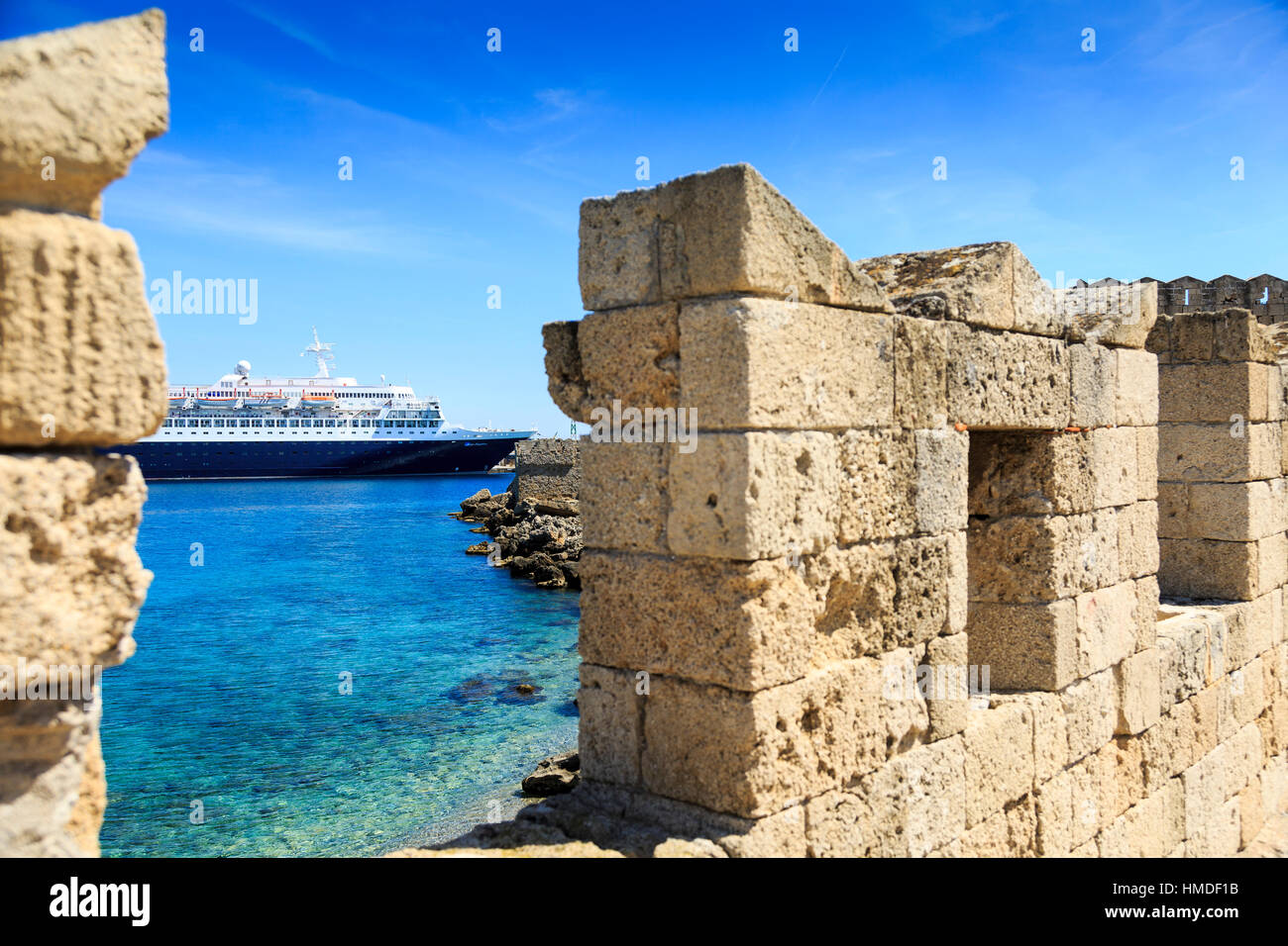 cruise ship moored in rhodes town, rhodes greece, viewed through old city walls Stock Photo