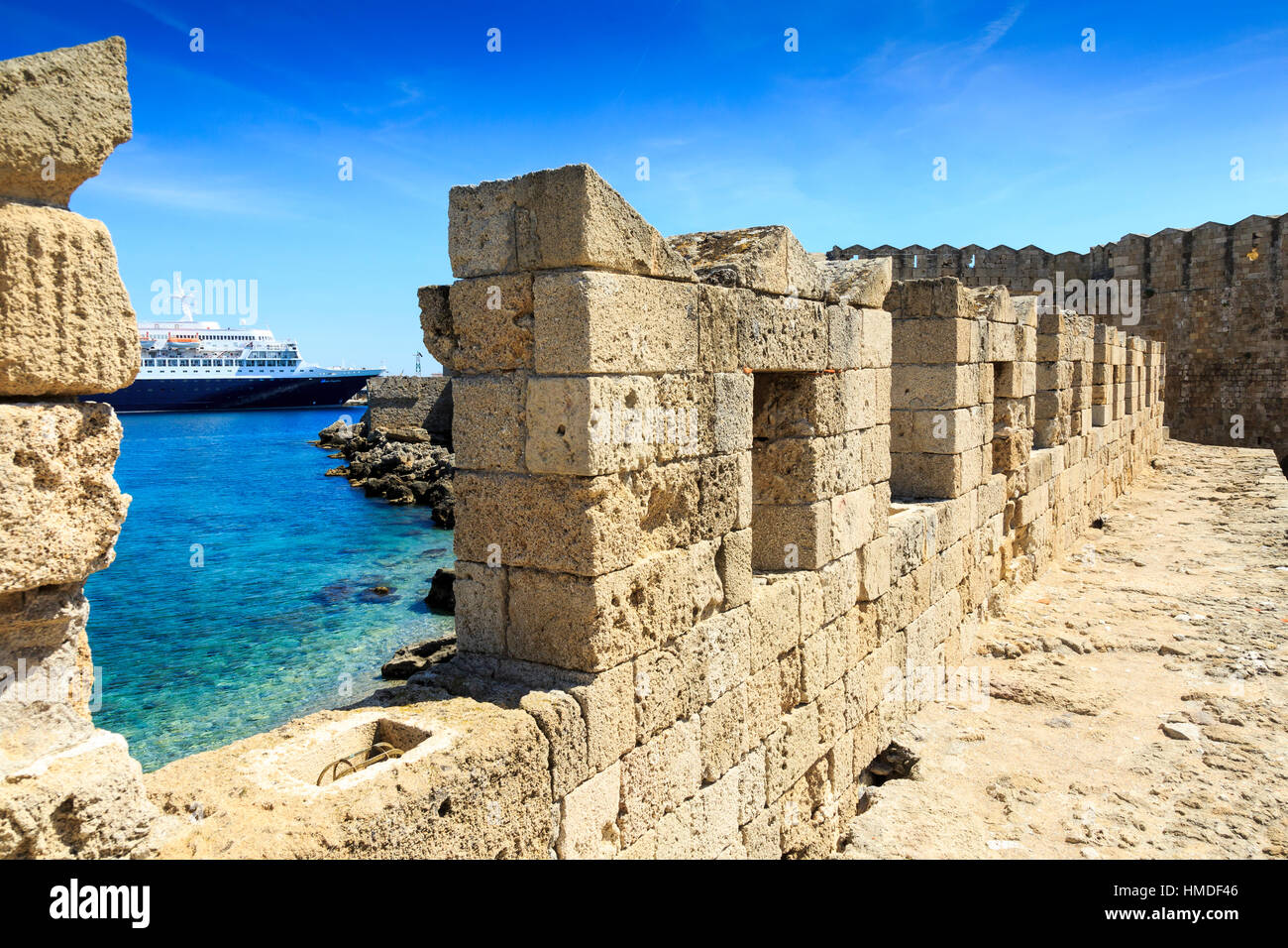 cruise ship moored in rhodes town, rhodes greece, viewed through old city walls Stock Photo