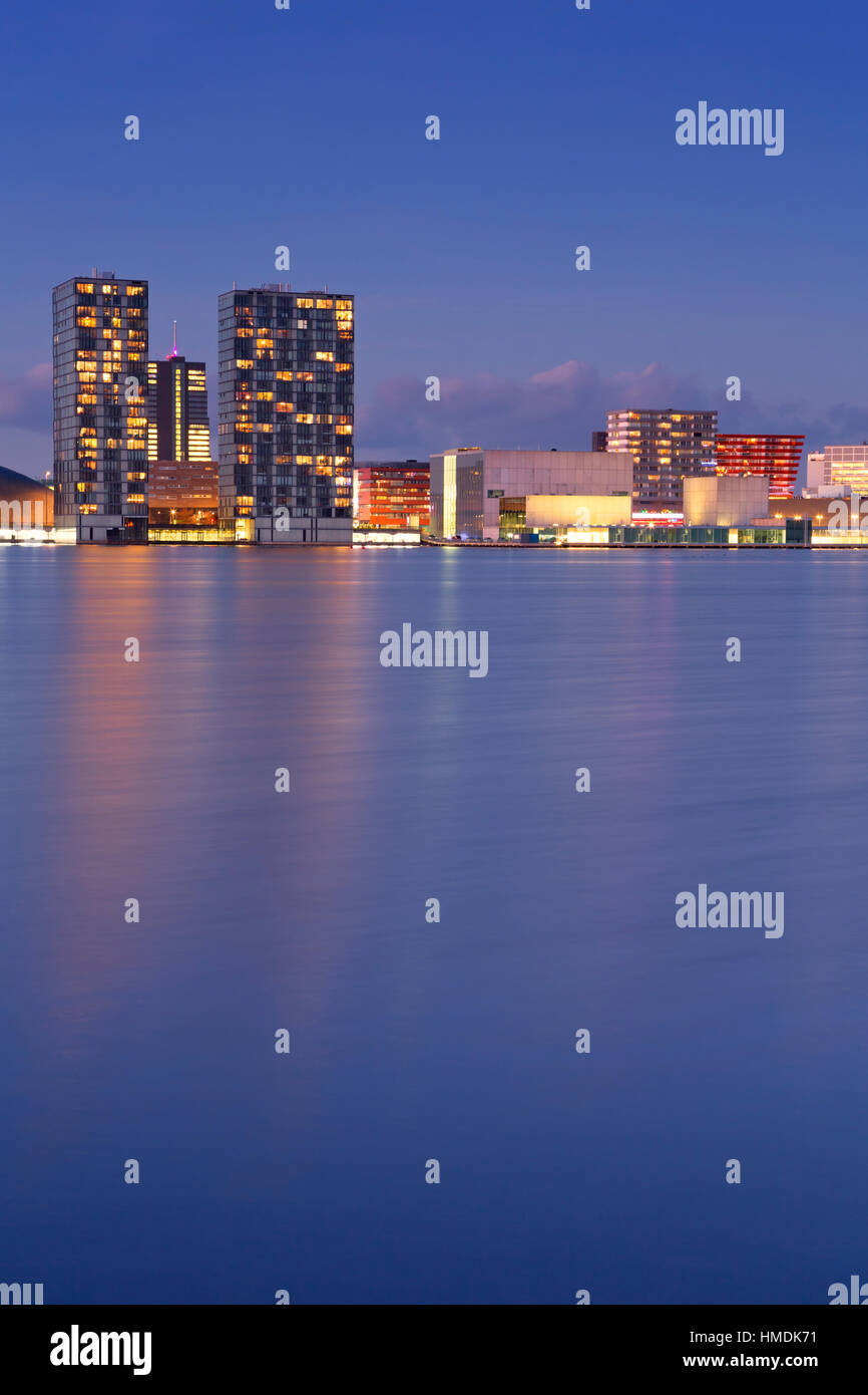 The skyline of the city of Almere in The Netherlands, photographed from across the water at dusk. Stock Photo