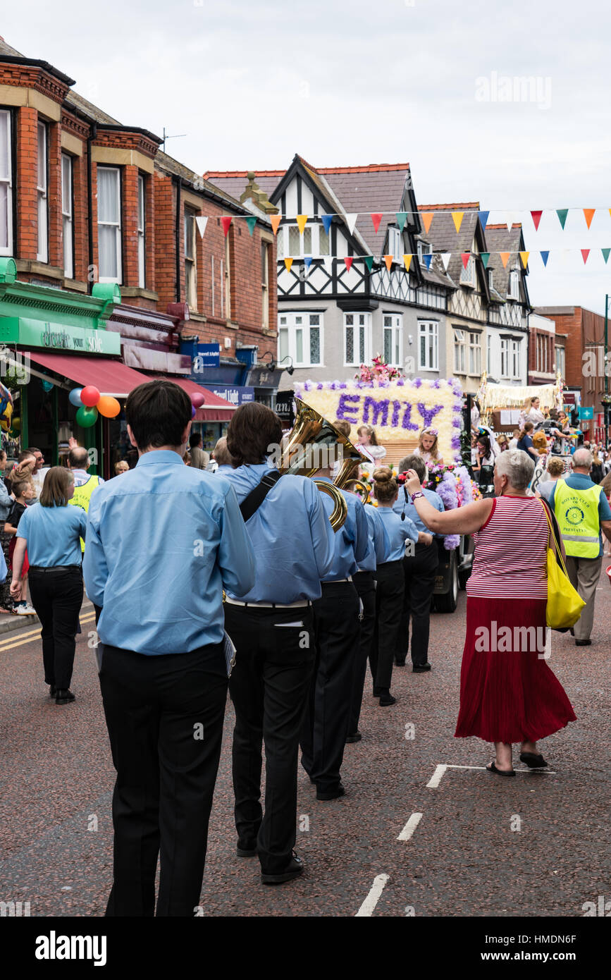 A junior brass band marches down the high street in the Prestatyn