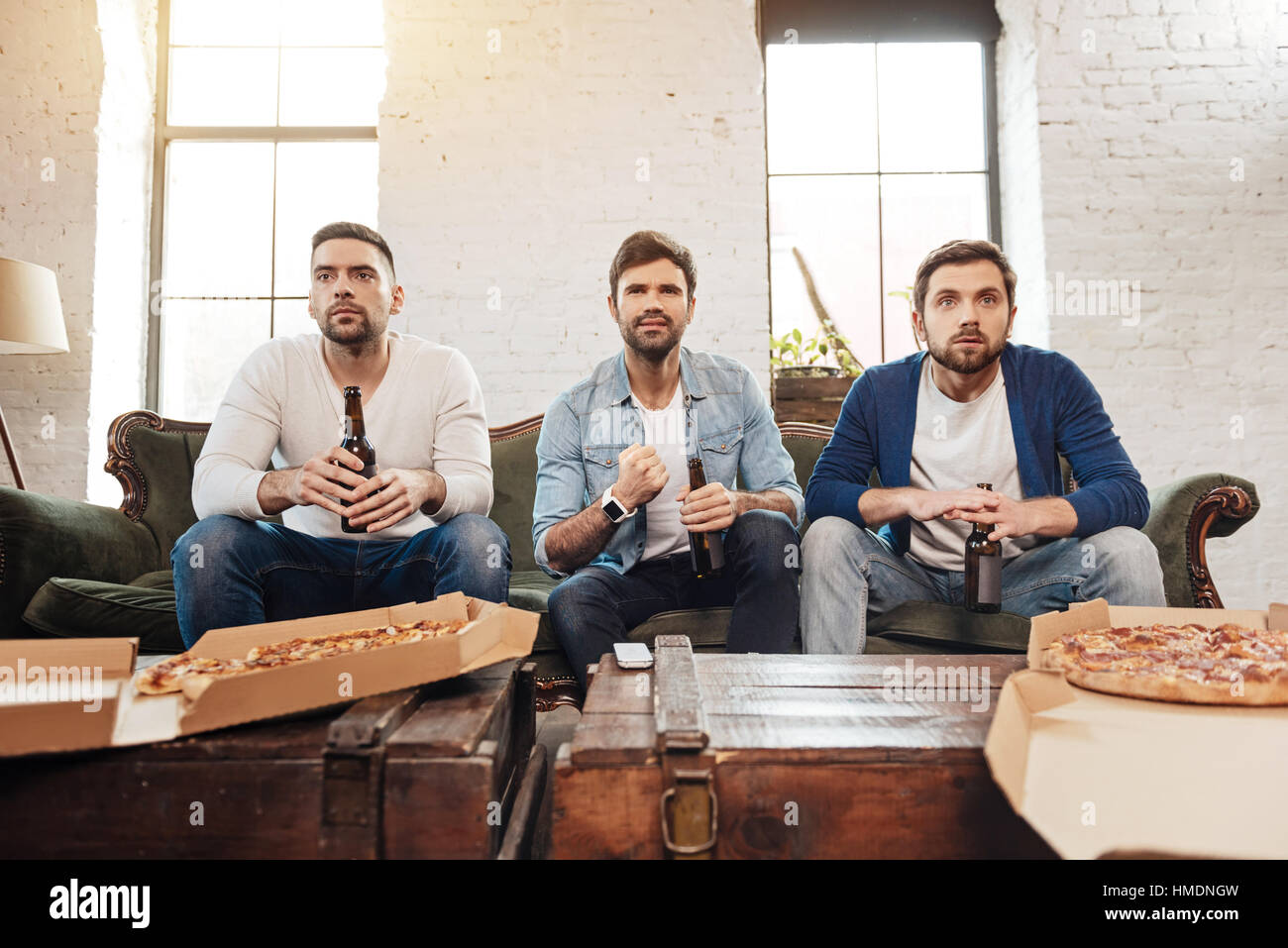 Serious young men watching football Stock Photo