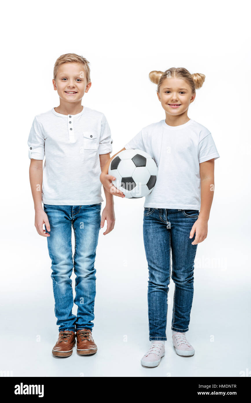 Smiling children standing with soccer ball Stock Photo