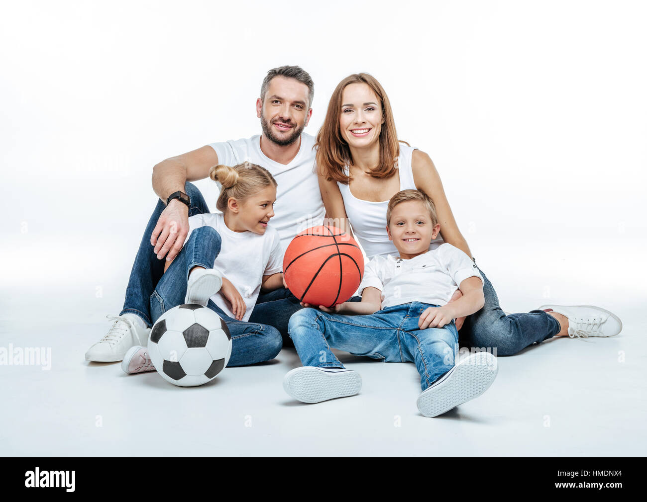 Cheerful family with soccer and basketball balls Stock Photo