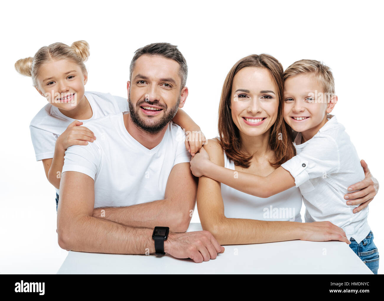 Smiling family in white t-shirts hugging Stock Photo