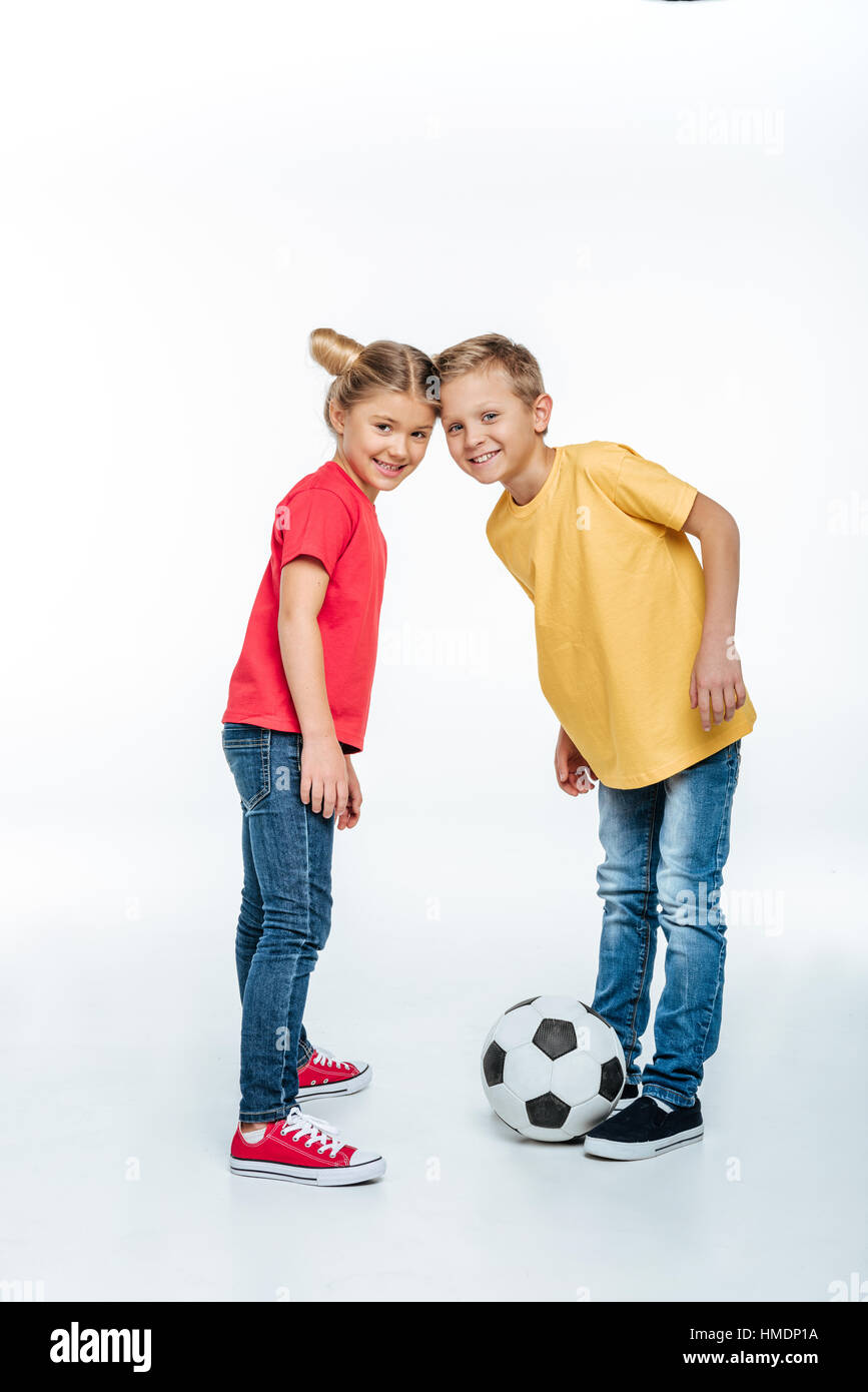 siblings standing with soccer ball Stock Photo