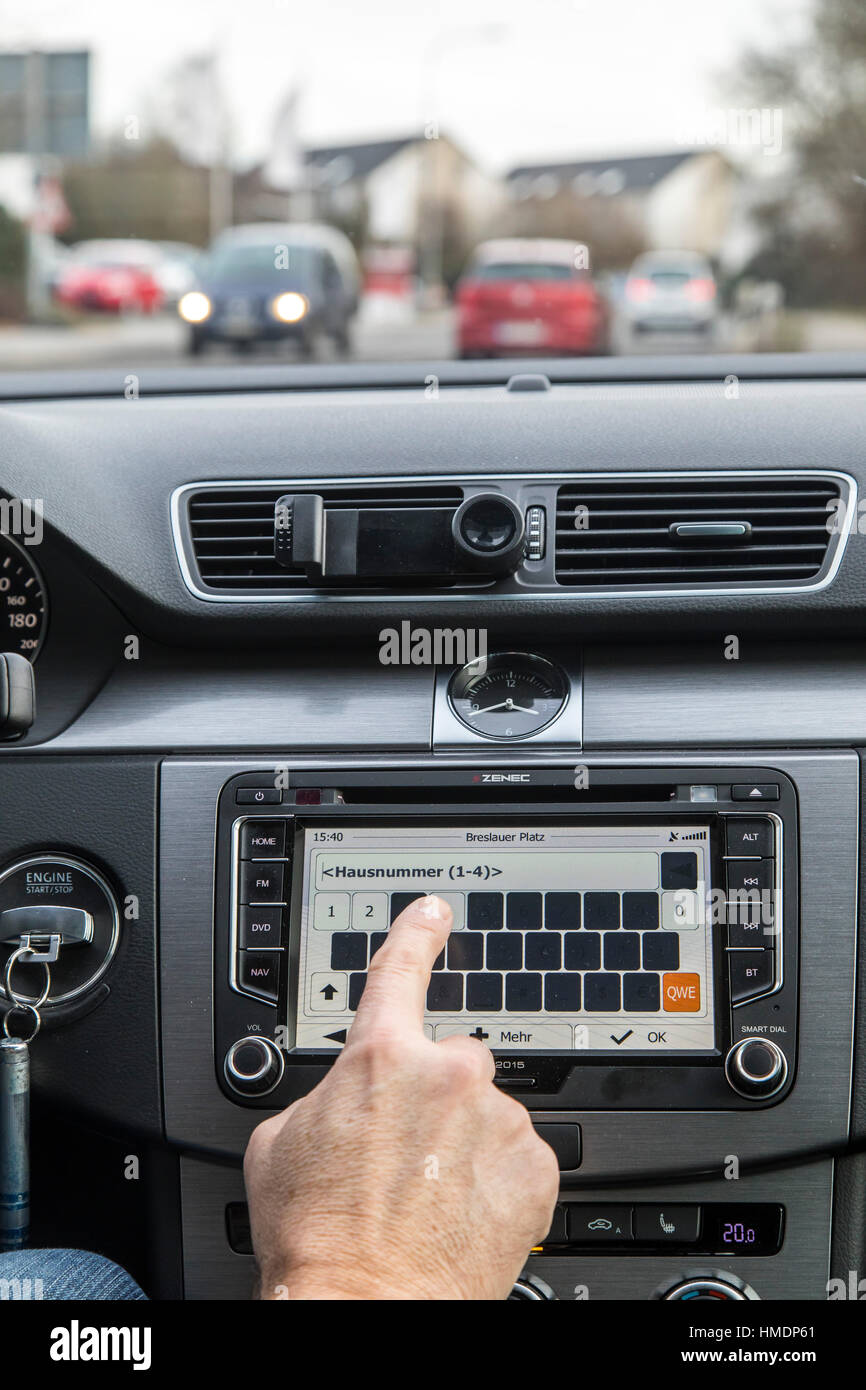 A car driver is using the cars navigation system, while driving the car