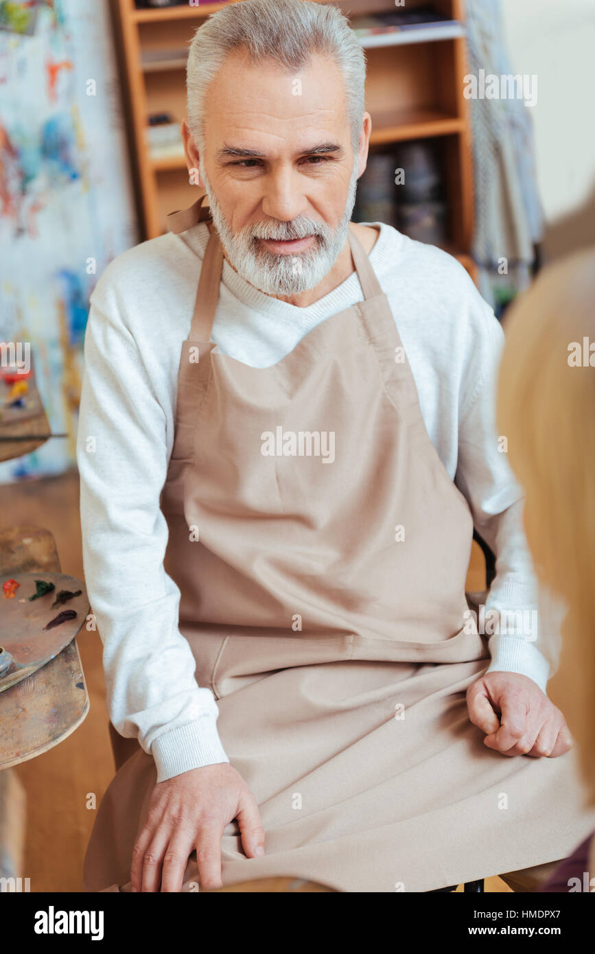 Concentrated artist wearing uniform in painting class Stock Photo Alamy