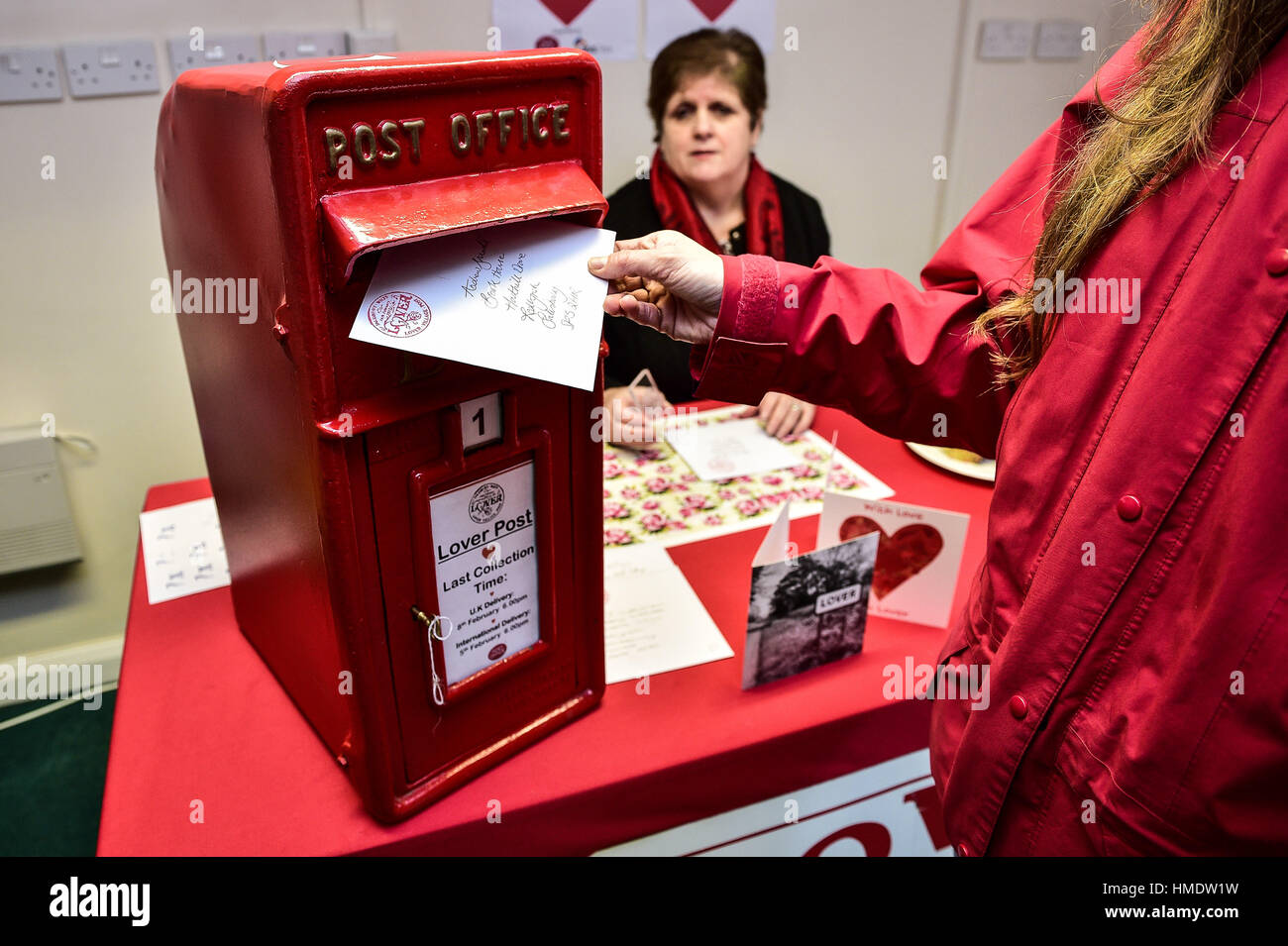 A woman posts a Valentines day card in the pop-up post office in the village of Lover, New Forest, where residents have launched a Valentine's Day post service, allowing romantics around the world to send a card from the Wiltshire village. Stock Photo