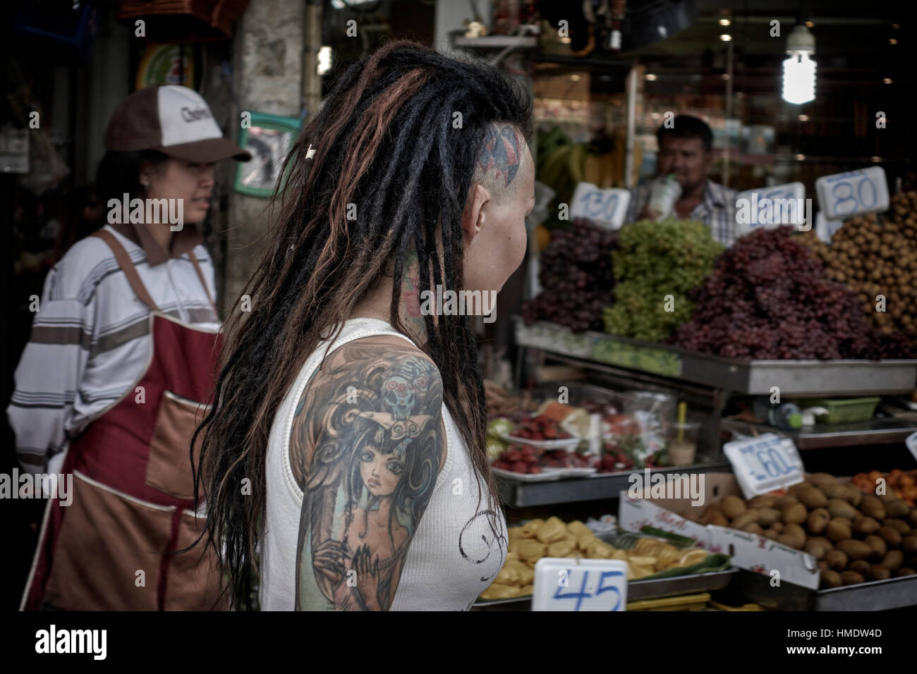 Woman tattoo. Dreadlocks hair extensions, a shaven tattooed head and arm tattoos. Pattaya Thailand Southeast Asia Stock Photo