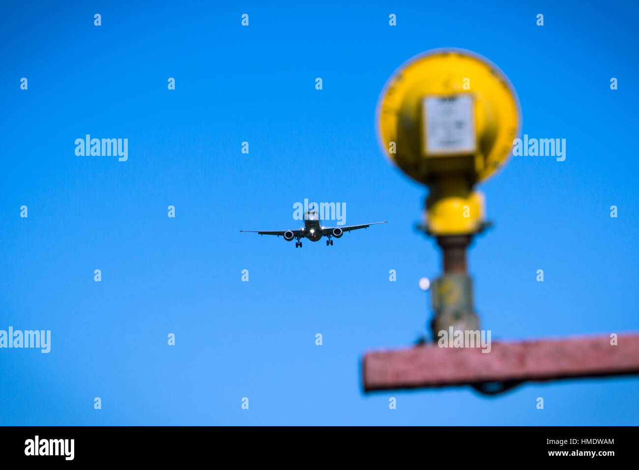 Jet airplane flying overhead close-up on a blue sky background Stock Photo