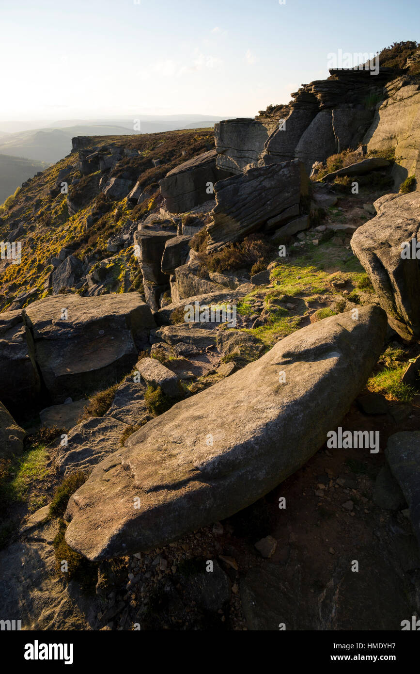 Rocks on Bamford edge in the Peak District park with summer sunlight on the hillside. A rugged Derbyshire landscape. Stock Photo
