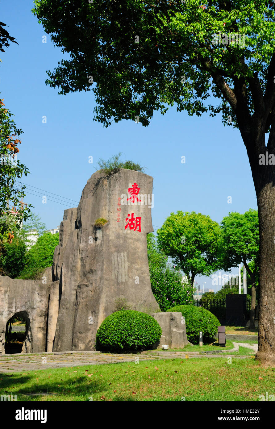 A rock at a park with the traditional chinese characters dong hu meaning  east lake in the city of shaoxing china on a blue sky day in Zhejiang  provinc Stock Photo -