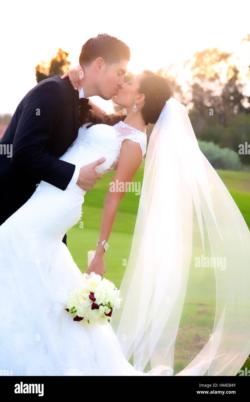 happy groom dipping and kissing his bride at sunset Stock Photo - Alamy