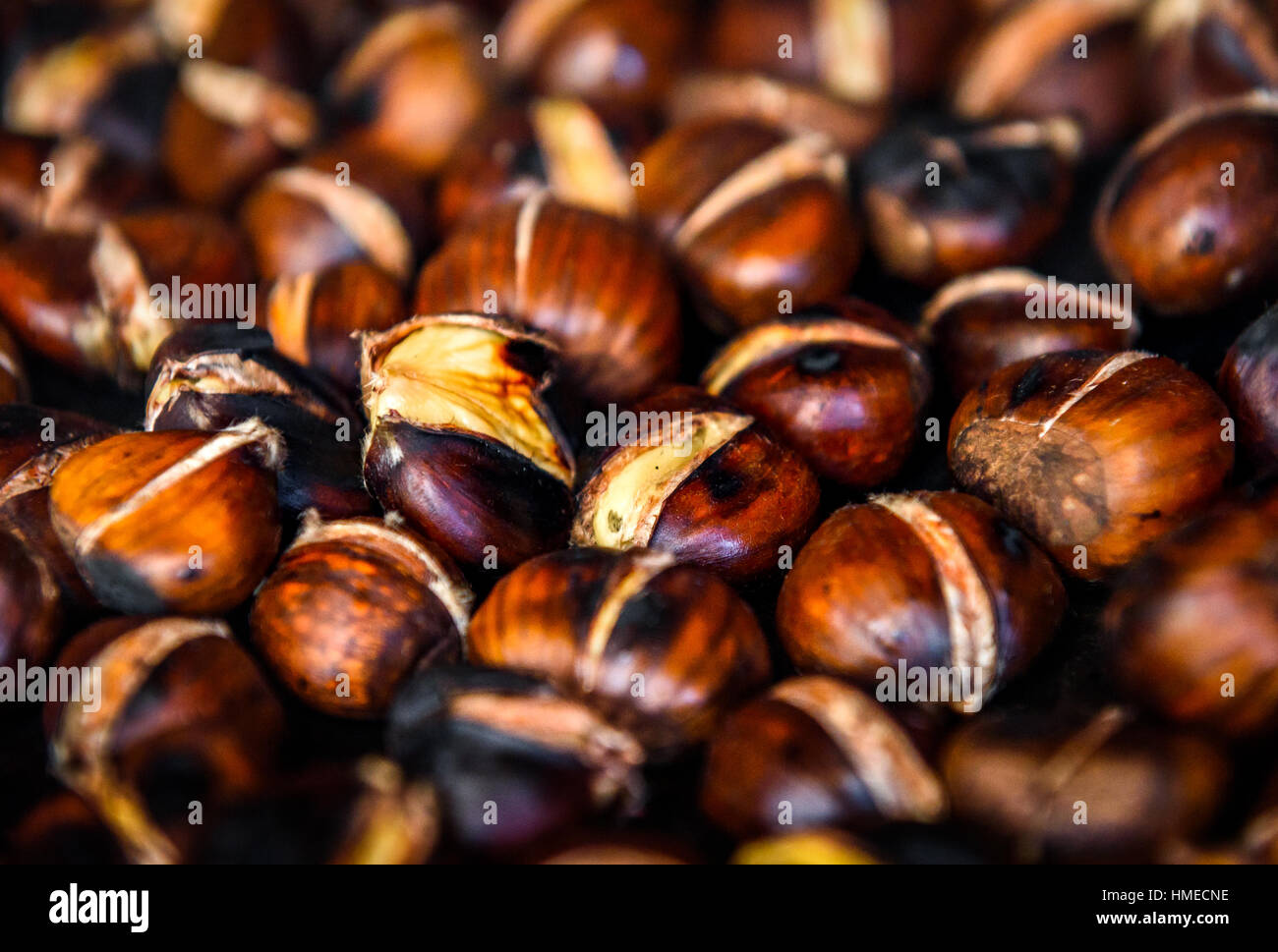 Roasting grilled Chestnuts on barbecue with flames, fire and charcoal. Homemade roasted chestnuts are prepared in BBQ grill fireplace. Stock Photo