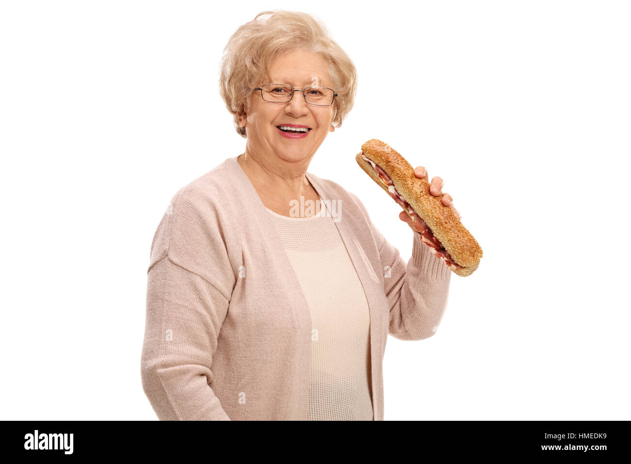 Cheerful elderly woman having a sandwich isolated on white background