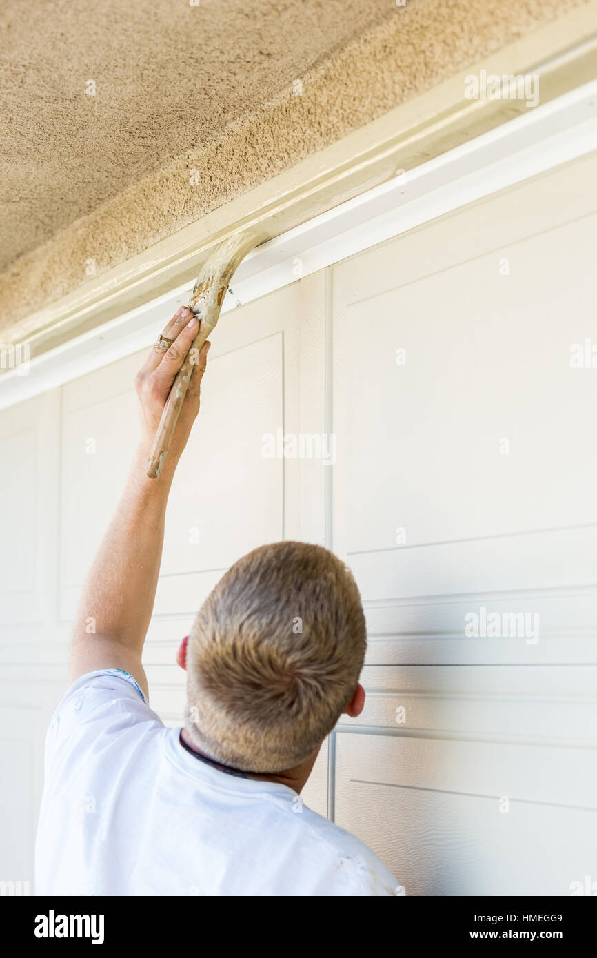 Professional Painter Cutting In With A Brush to Paint Garage Door Frame
