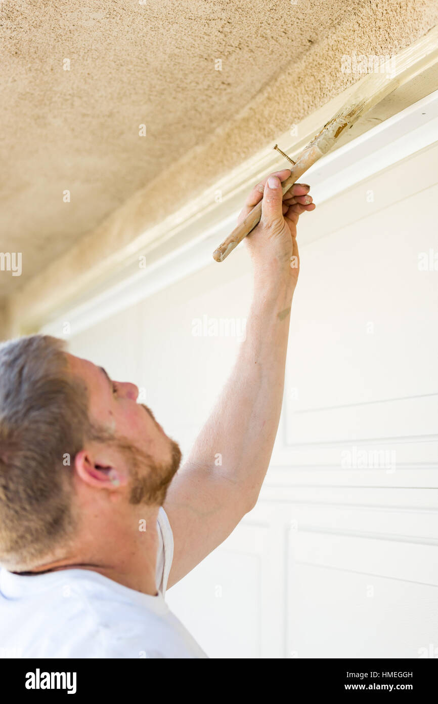 Professional Painter Cutting In With A Brush to Paint Garage Door Frame