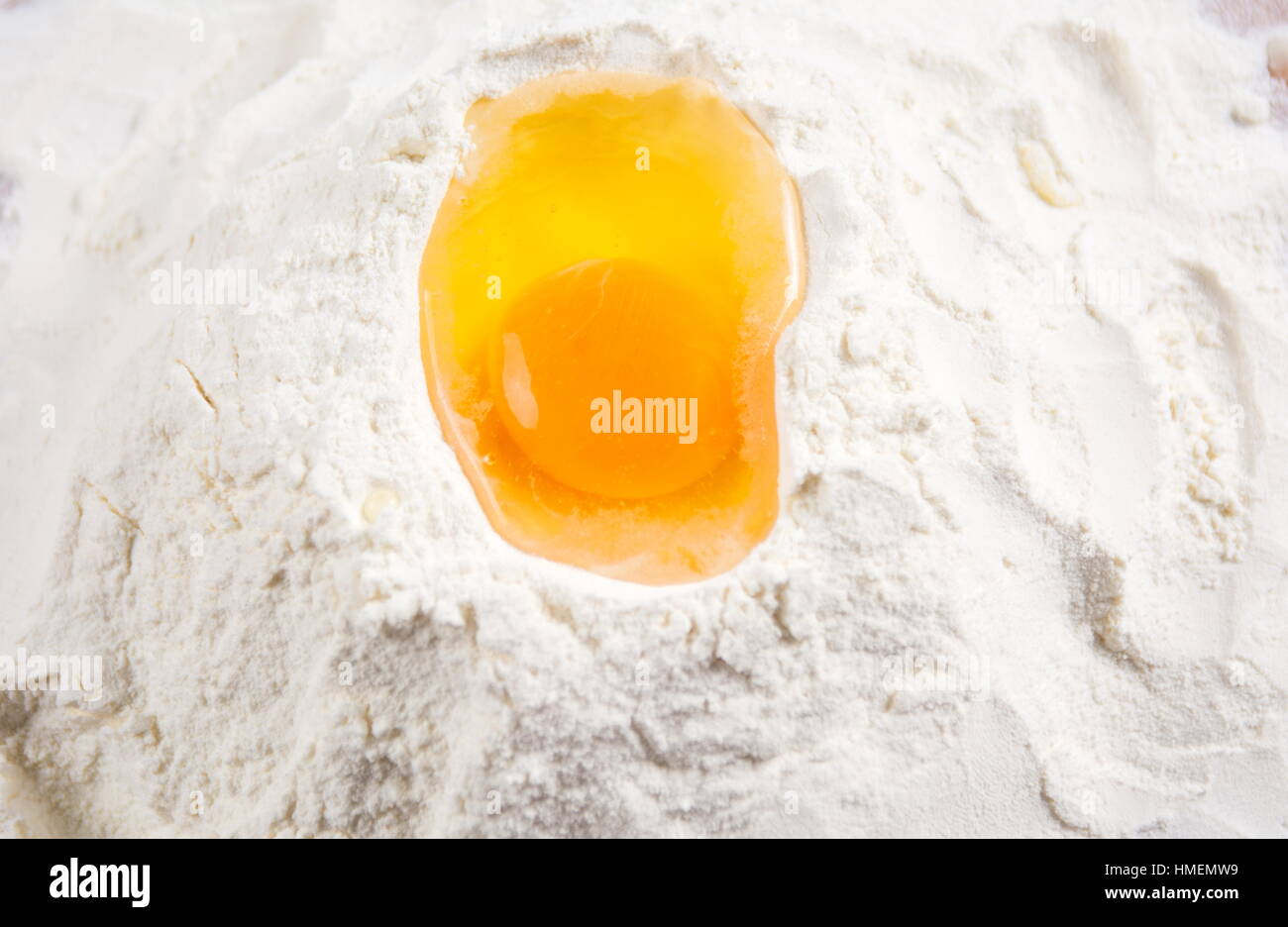 Broken chicken egg on a flour pile Stock Photo