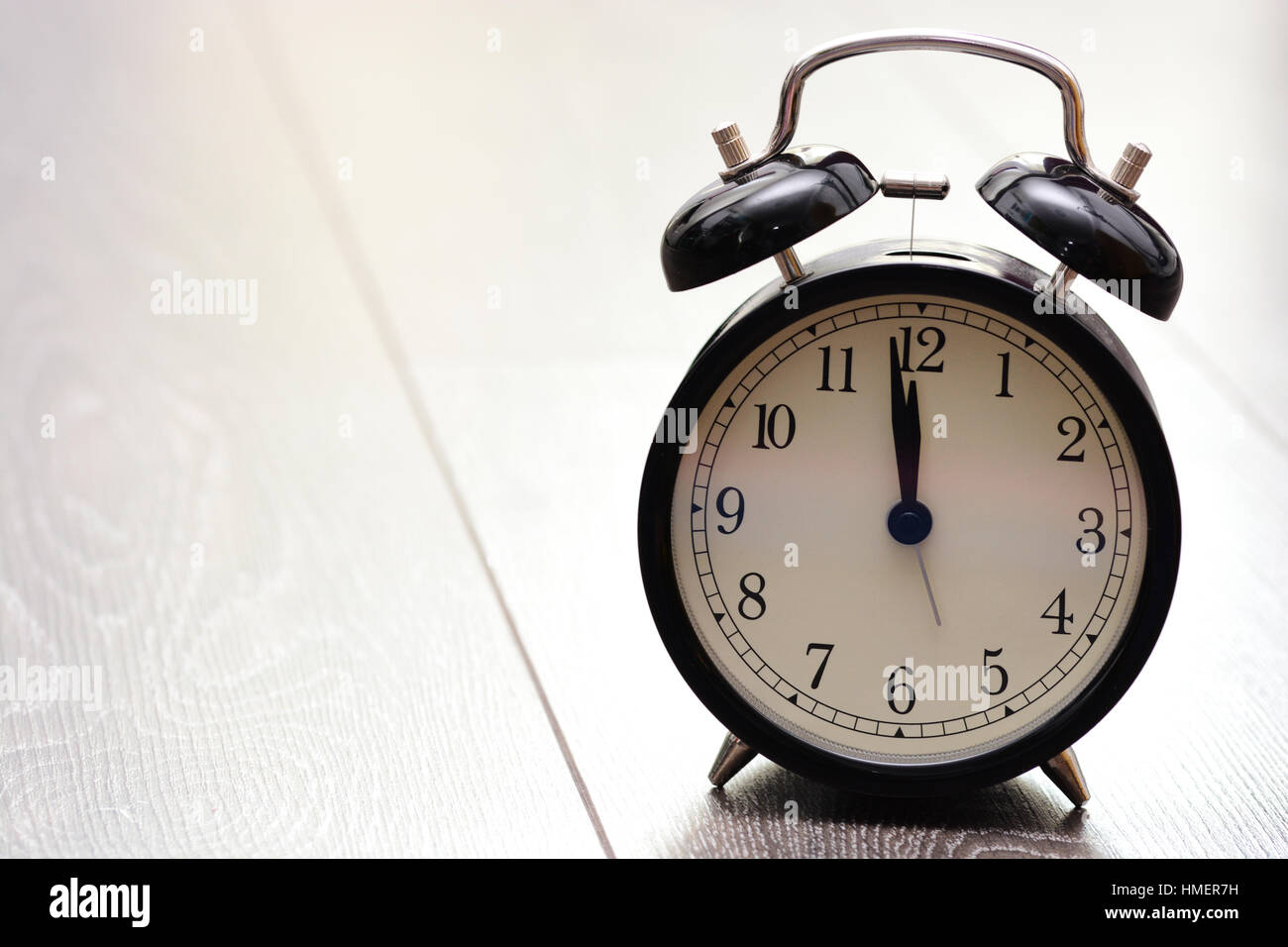 Retro bell alarm clock on wooden background Stock Photo