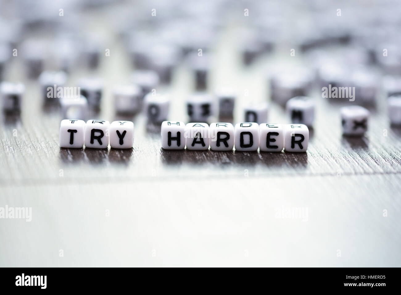 Try harder inspirational advice spelled by tiled letter beads Stock Photo