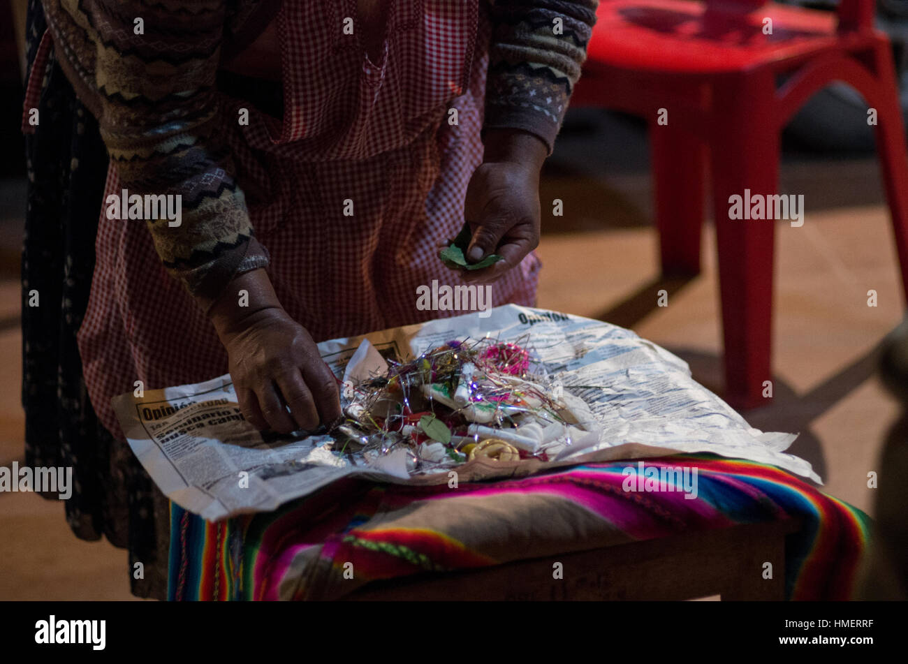 A woman adds coca leaves to a mesa offering for the mother earth deity