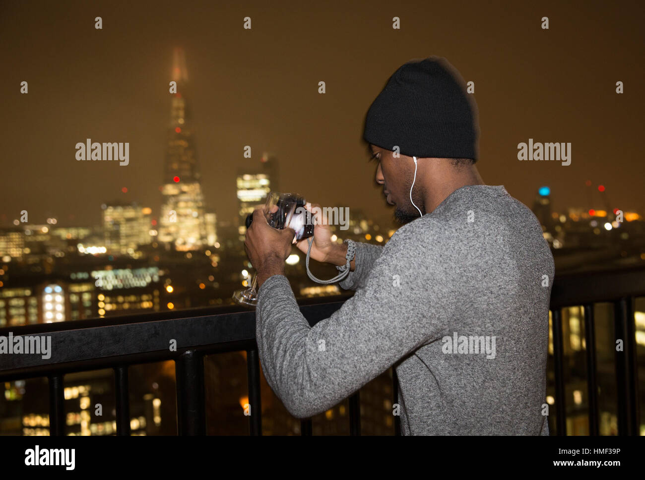 A photographer takes a photograph of the Shard from the balcony of the Tate Modern Switch House in London Stock Photo