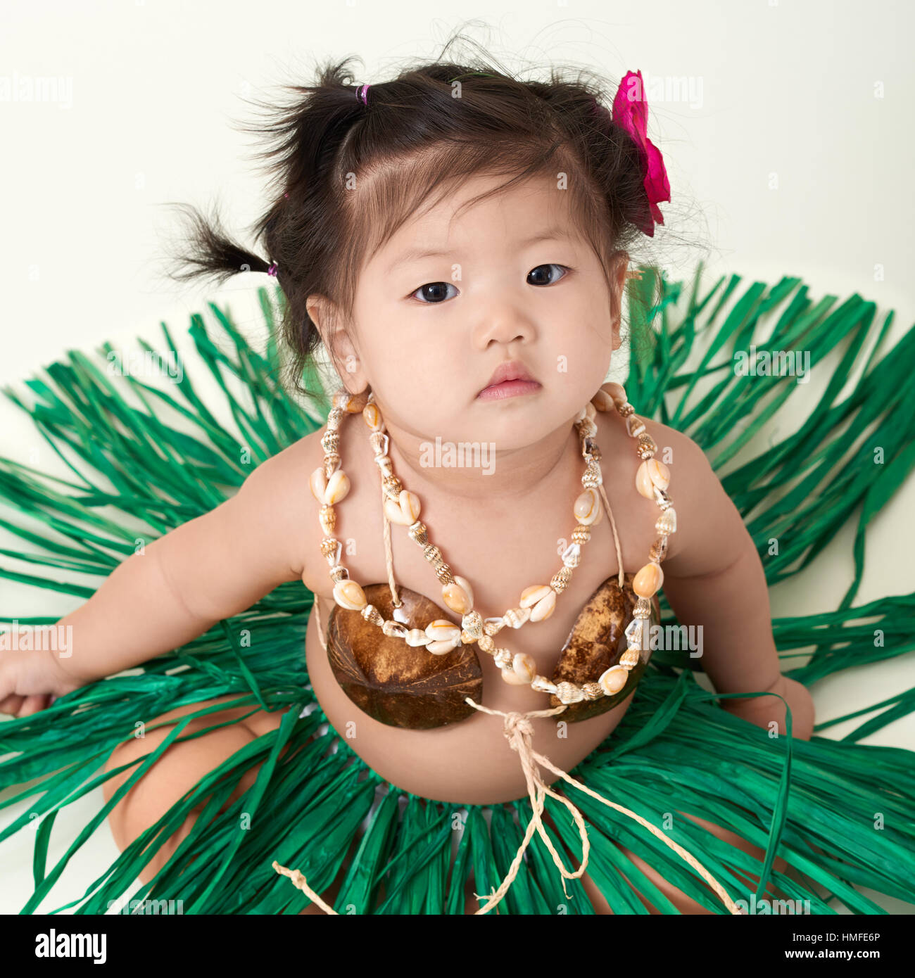 Cute Asian Chinese baby girl dressed in Hawaiian outfit. Stock Photo