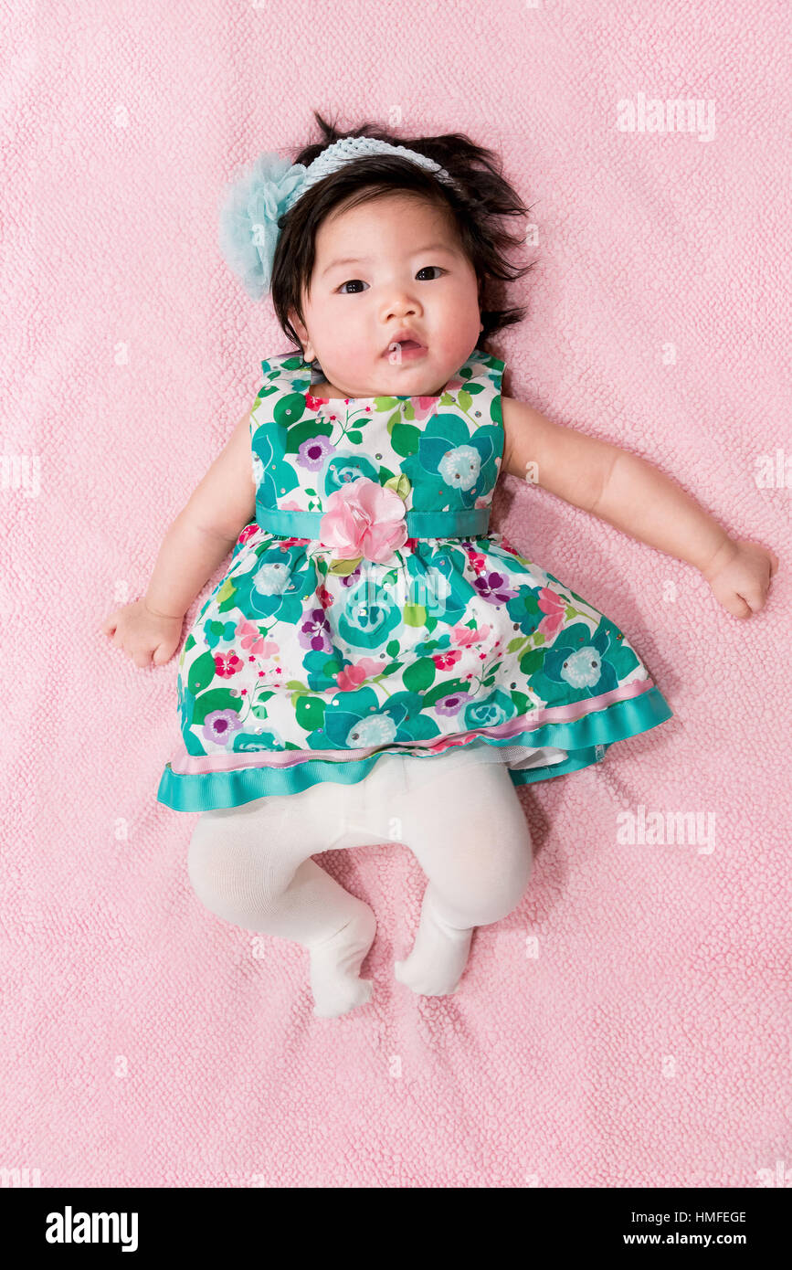 baby girl with cute floral dress and pink background Stock Photo - Alamy