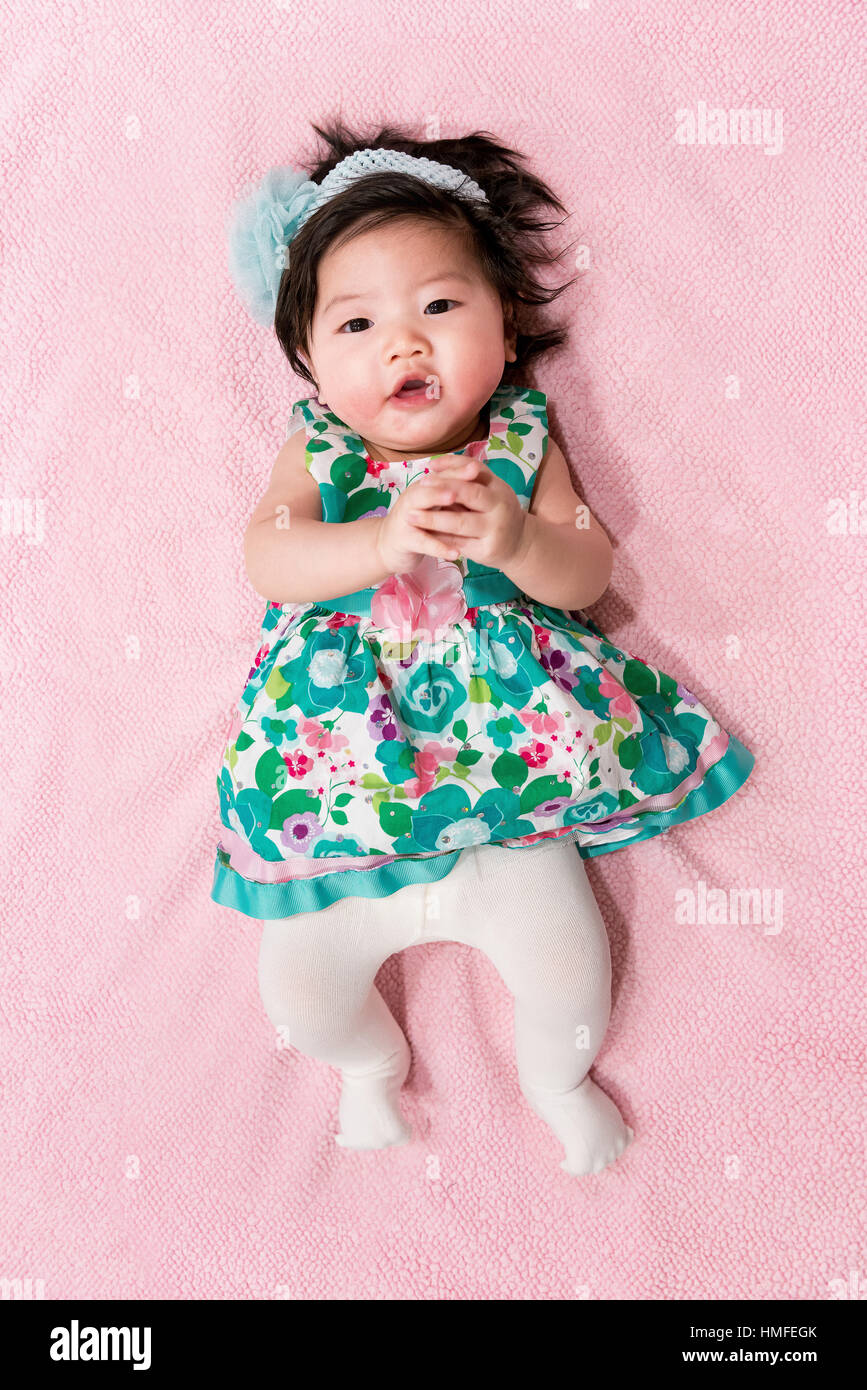 baby girl with cute floral dress and pink background Stock Photo - Alamy